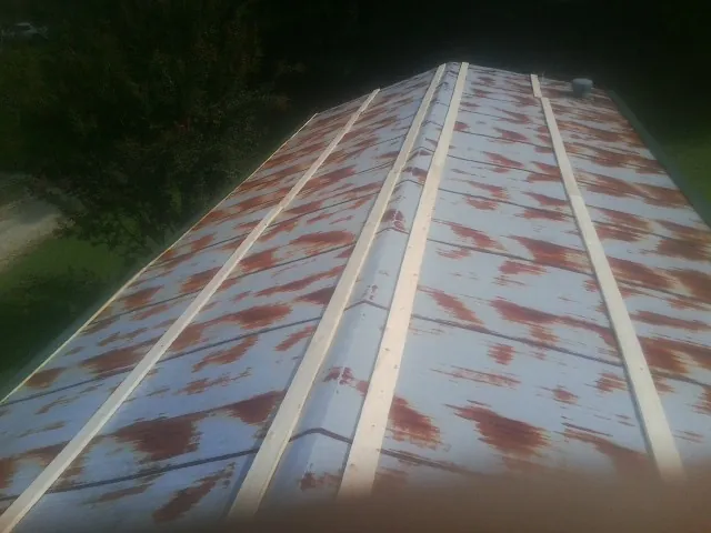 Rusted metal roof panels with new wood purlins before replacement — Storm Damage Roof Repair in Naperville by Roofing Brothers