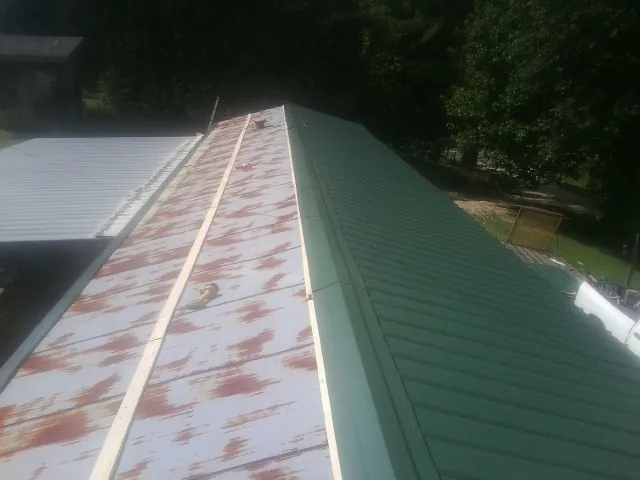 Old rusted panels beside newly installed green metal roofing — Wind Damage Roof Repair by Roofing Brothers in Naperville
